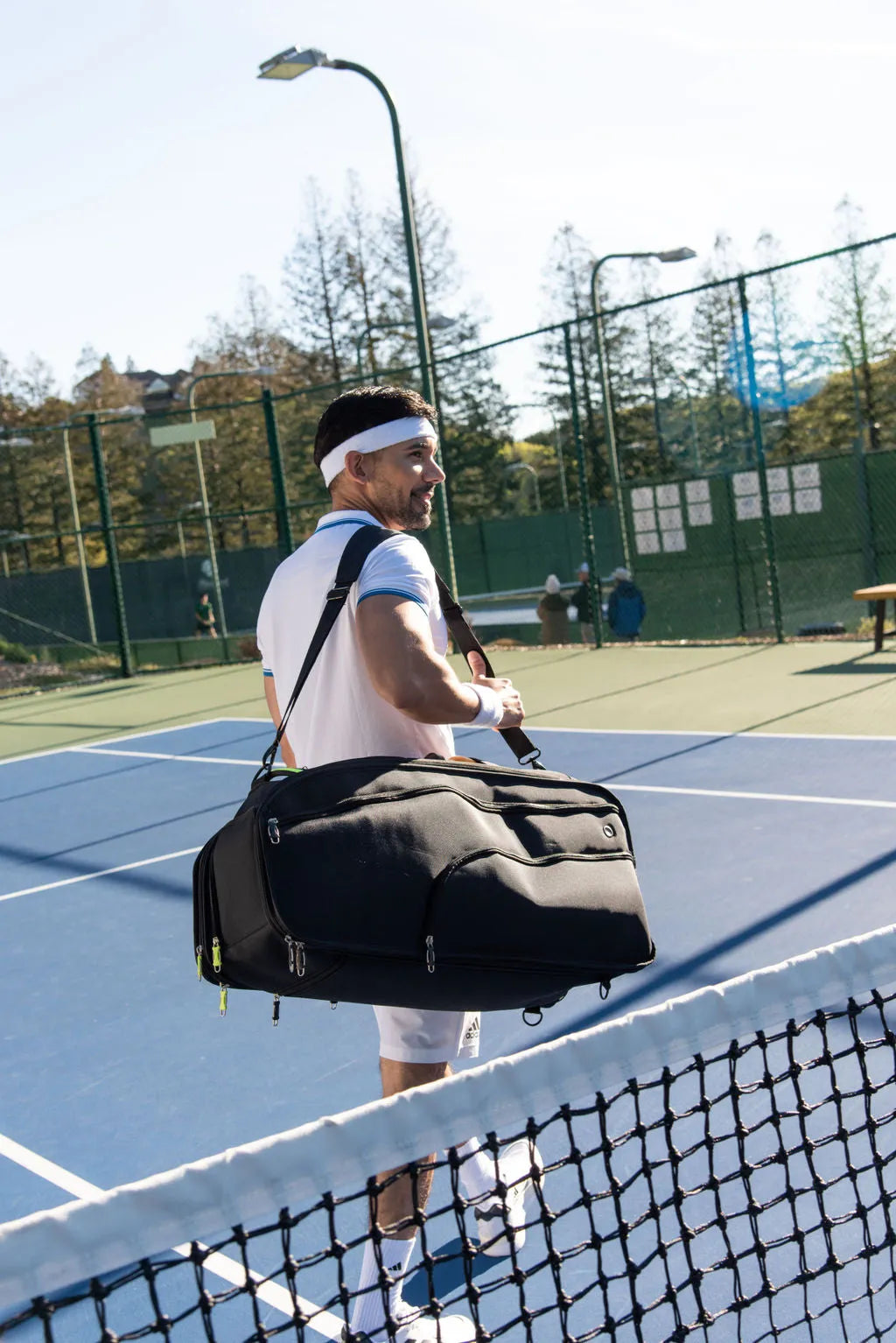 Player carrying The Rocket on one shoulder across a tennis court